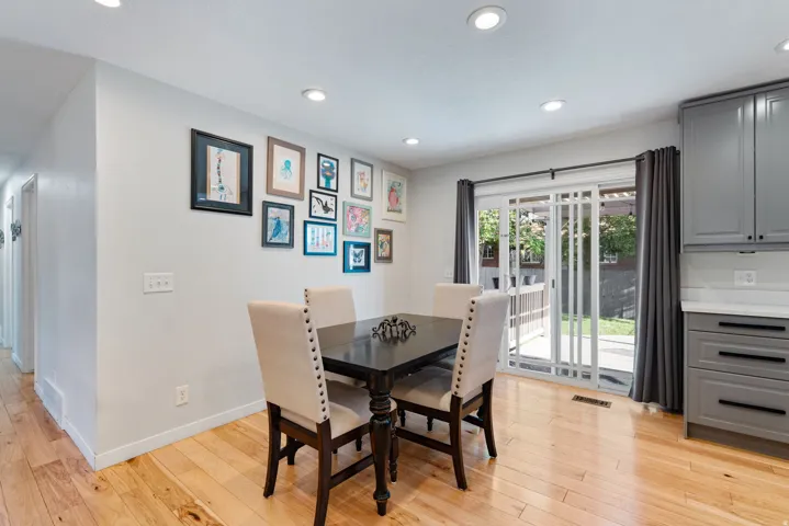 Dining area featuring light wood-finish flooring, recessed lighting, and a sliding glass door providing outdoor access