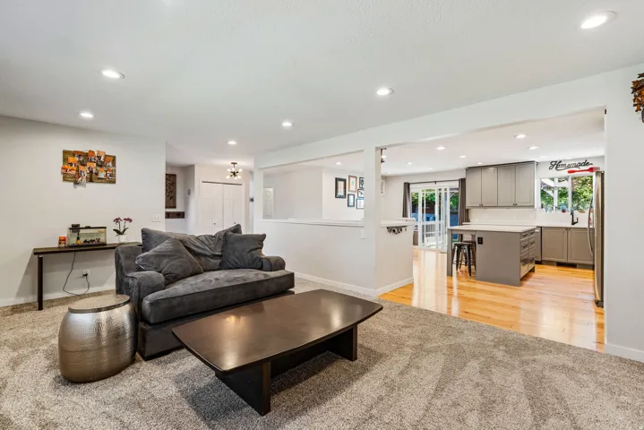 Spacious interior featuring a carpeted living area and a kitchen with wood-finish flooring