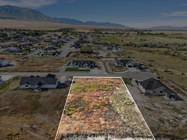 Expansive undeveloped land parcel featuring natural ground cover and distant mountain scenery