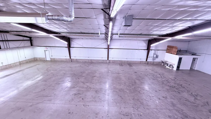 Concrete flooring, exposed structural beams, fluorescent lighting, insulated ceiling, corrugated metal wall panels