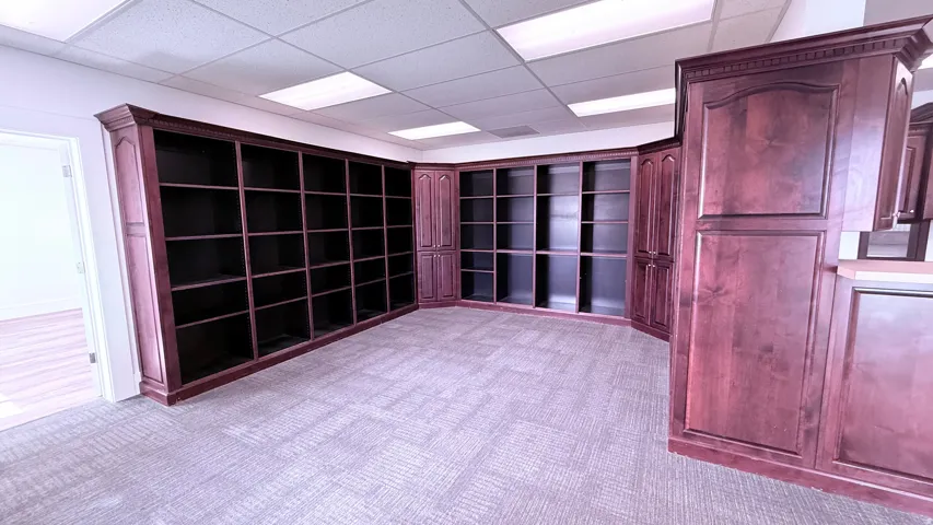 Built-in custom cabinetry, extensive shelving, recessed ceiling lights, and carpeted flooring