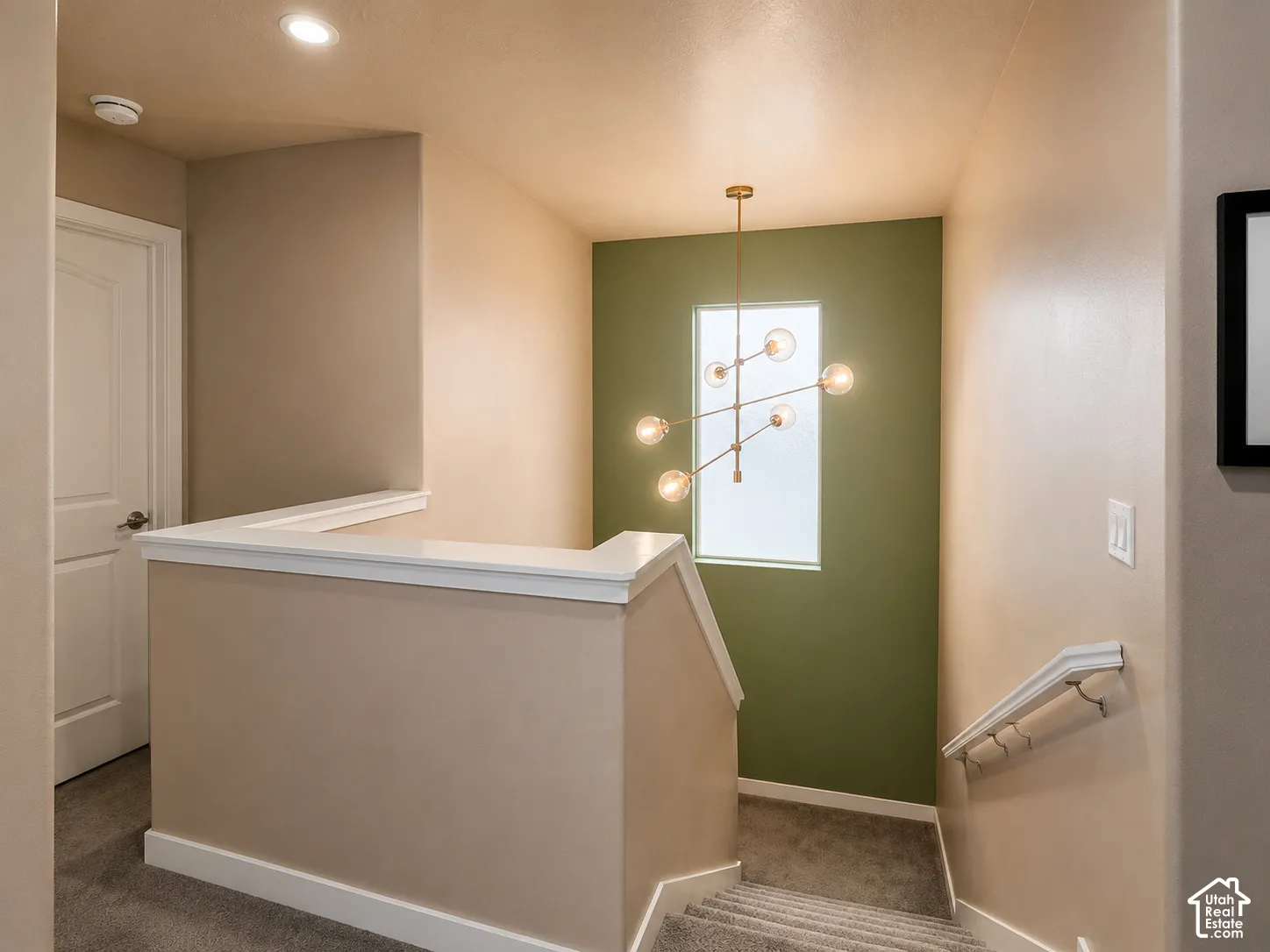 Modern chandelier illuminating a landing with a window feature