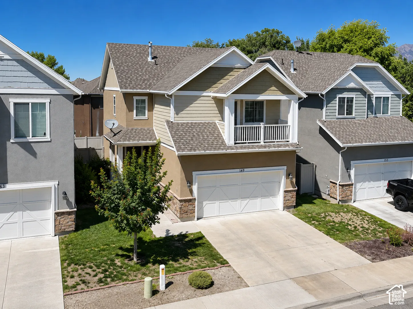 Two-story home with a two-tone facade, prominent balcony, and an attached two-car garage