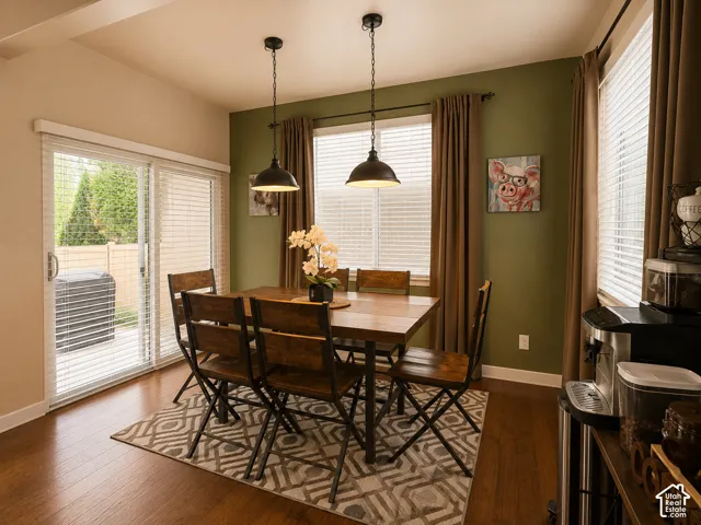Dining area featuring warm wood-finish flooring and a sliding glass door to the exterior