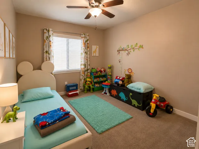 Carpeted room featuring a ceiling fan with integrated lighting, a window with blinds, and neutral-toned walls