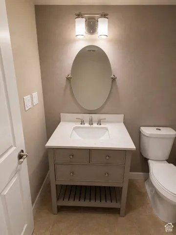 Bathroom vanity with a light gray wood-finish, featuring a white sink, chrome faucet, and stone-finish countertop