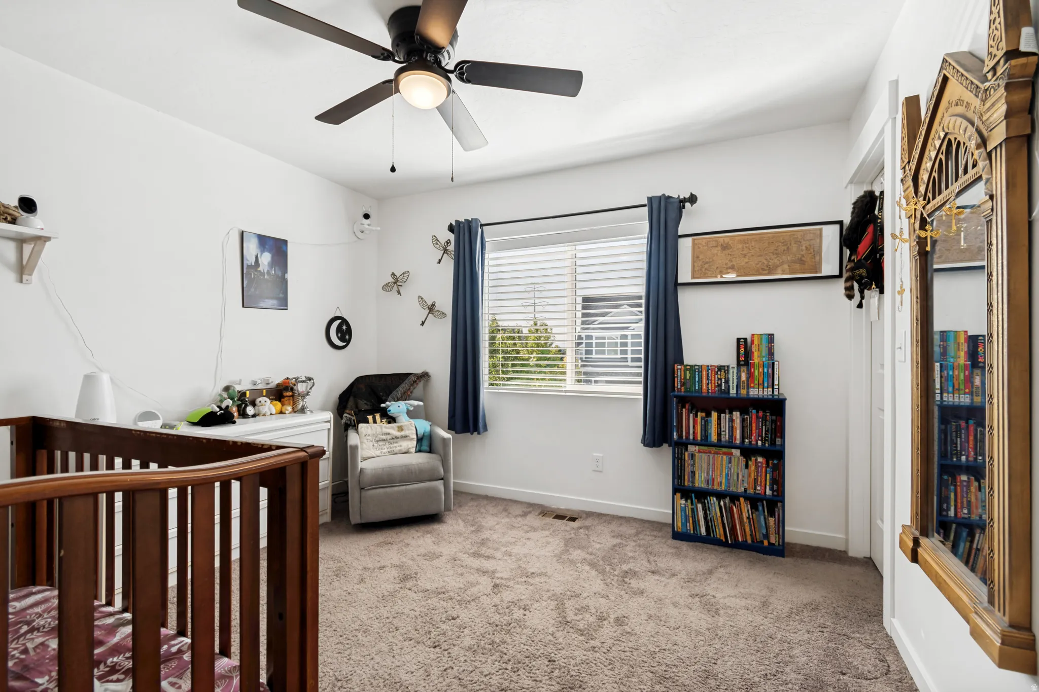 Carpeted room featuring a ceiling fan with integrated lighting, a window with blinds and drapes, and white walls