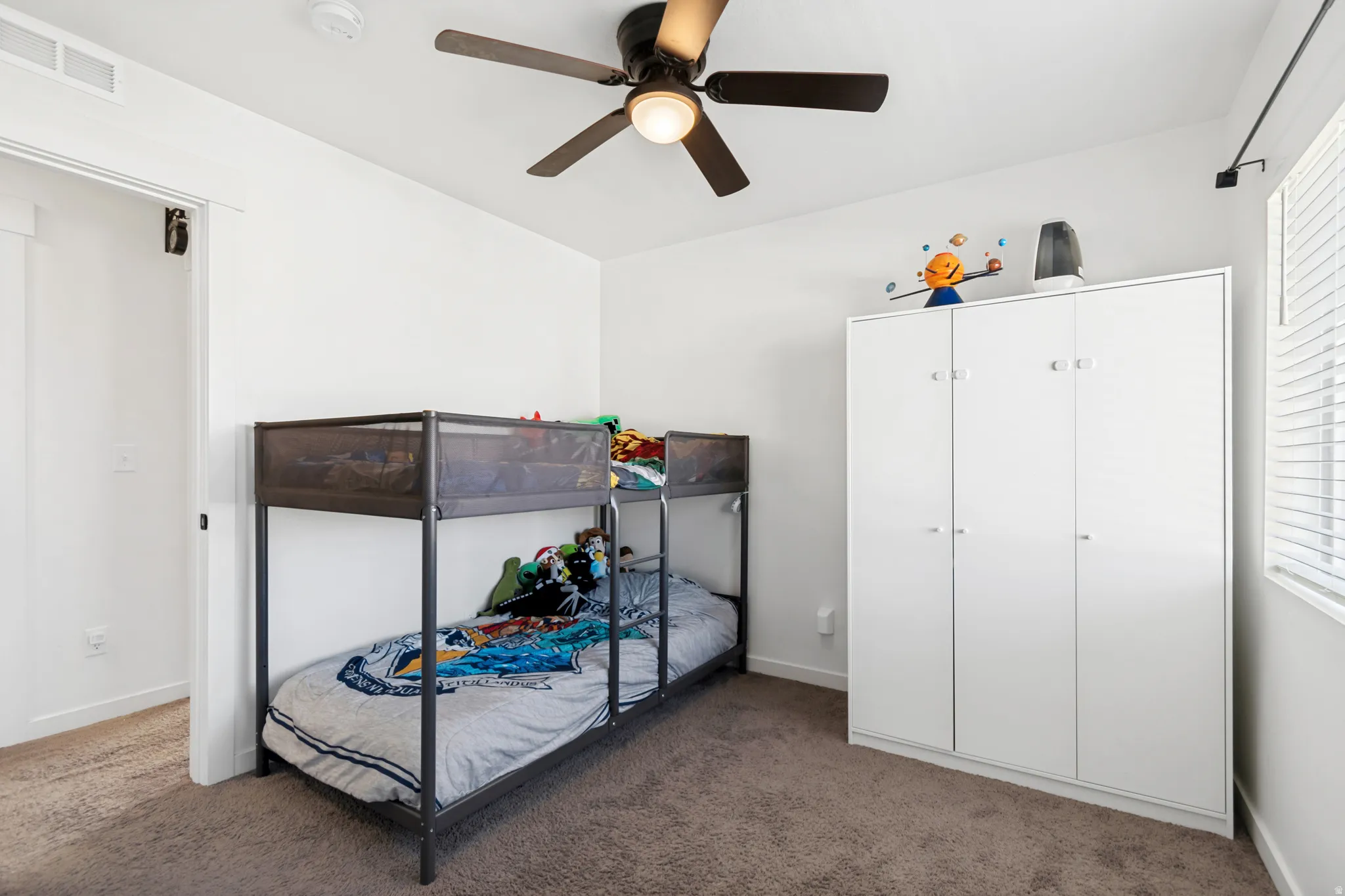 Neutral-toned carpeted flooring with white baseboards