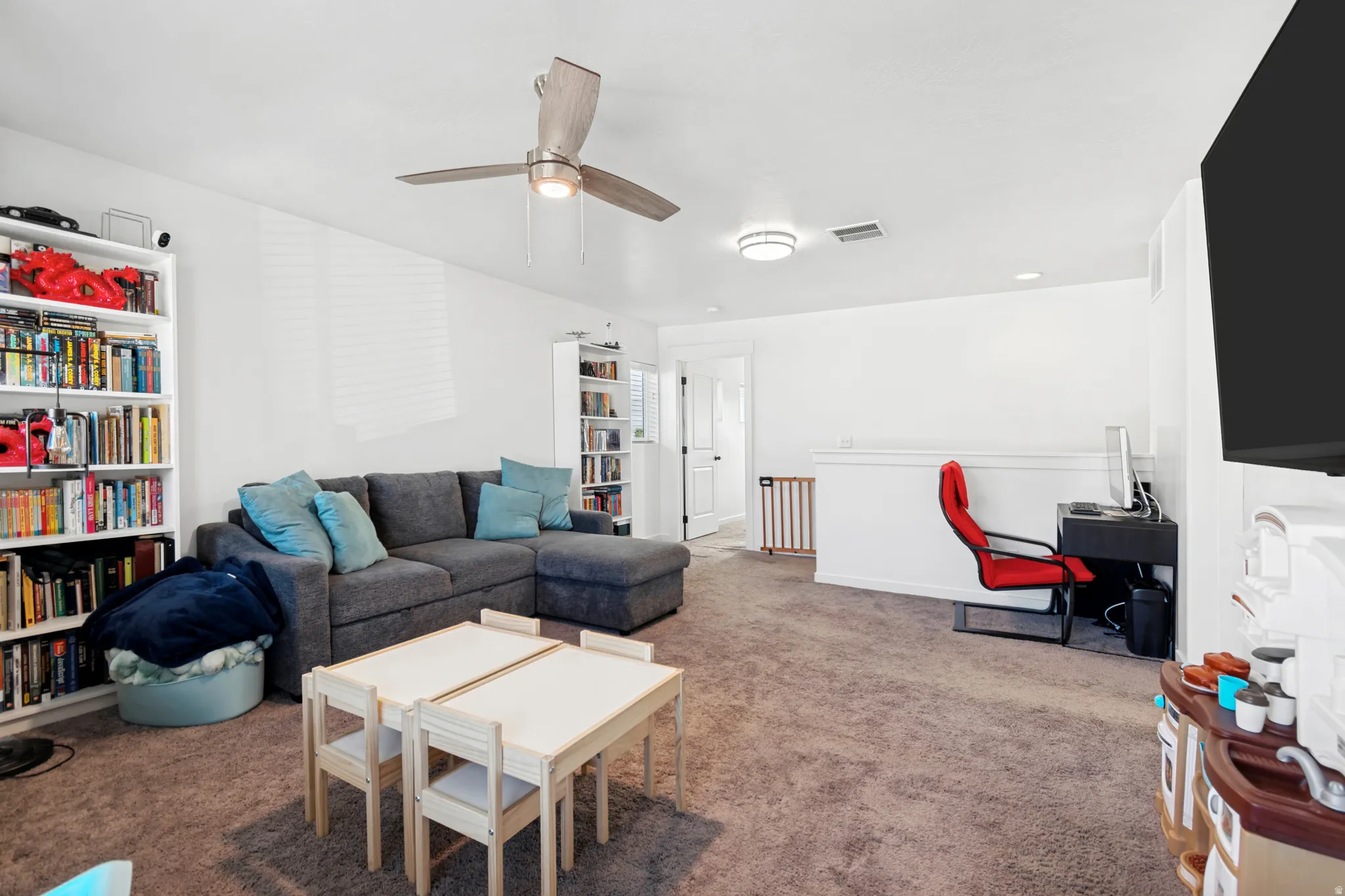 Loft featuring white walls and a ceiling fan
