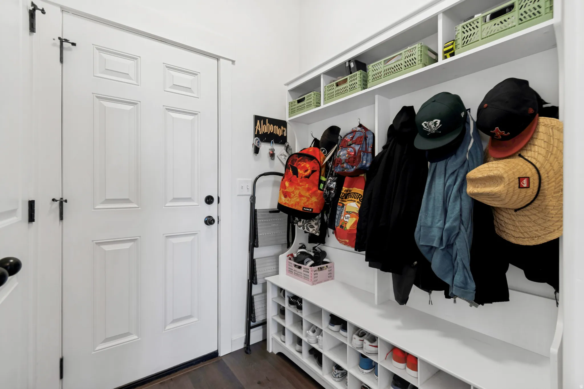 Dedicated mudroom area featuring built-in shelving, coat hooks, and shoe cubbies