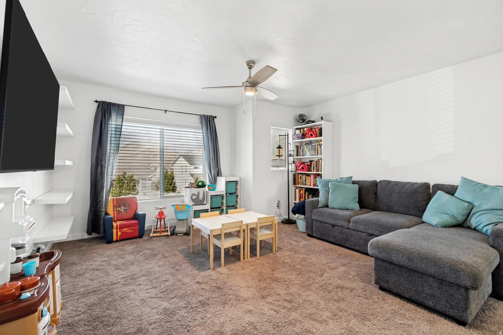 Loft featuring white walls and a ceiling fan