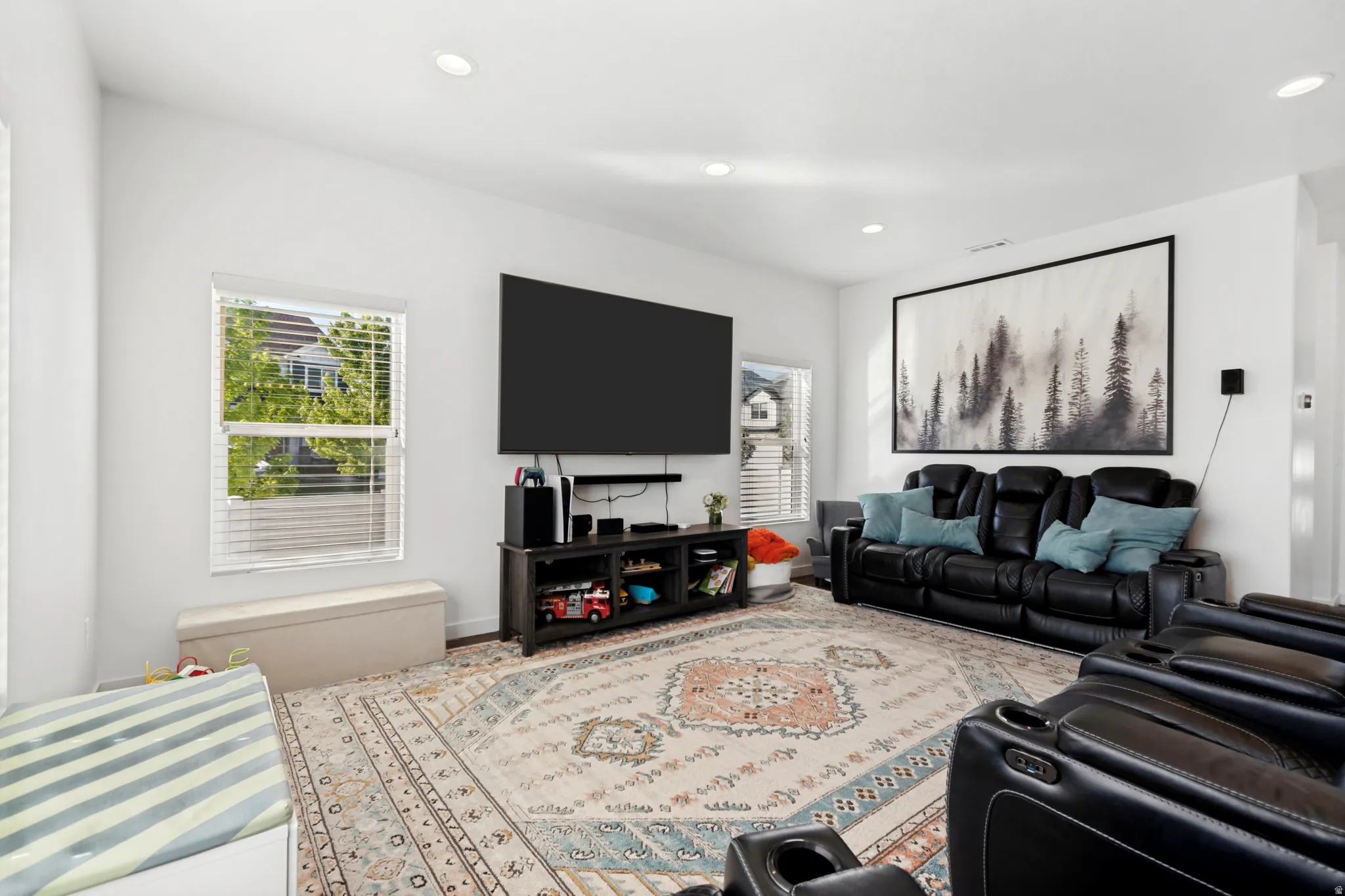 Spacious living area featuring recessed lighting, multiple windows with blinds, and white painted walls
