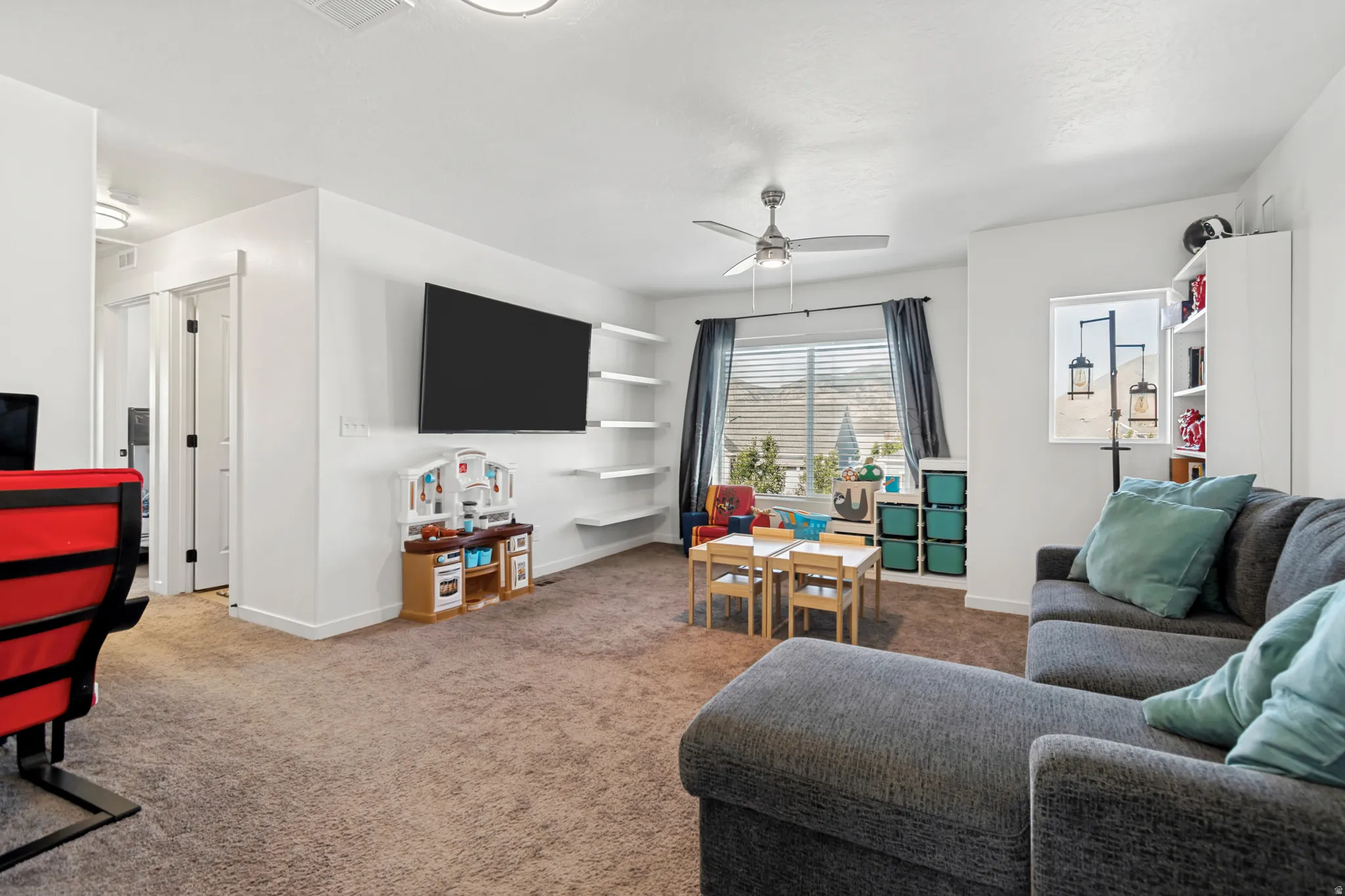 Loft featuring white walls and a ceiling fan