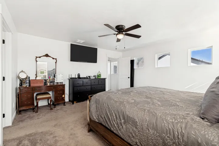 Carpeted room featuring white walls and a ceiling fan with integrated lighting