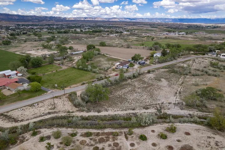 Aerial shows neighborhood view, canal and road as well as mountain view in the distance