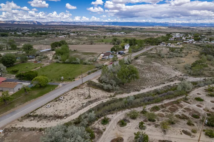 Aerial shows neighborhood view, canal and road as well as mountain view in the distance