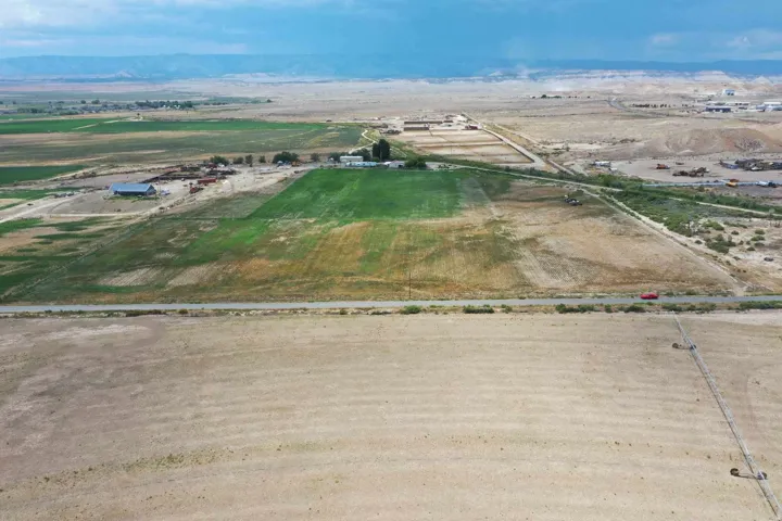 Expansive rural property featuring cultivated fields and a distant farmstead