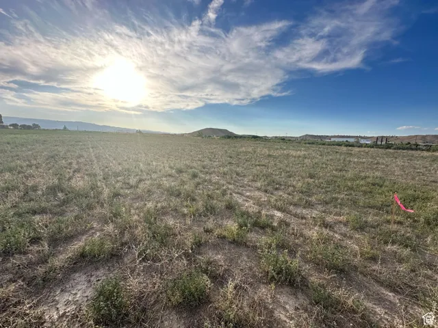 Expansive land parcel with varied ground cover and distant natural features