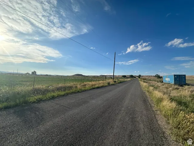 Paved road extending through open fields