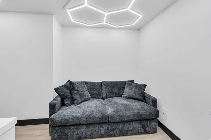 Recessed lighting, wood-finish flooring, and white walls create a bright and neutral interior