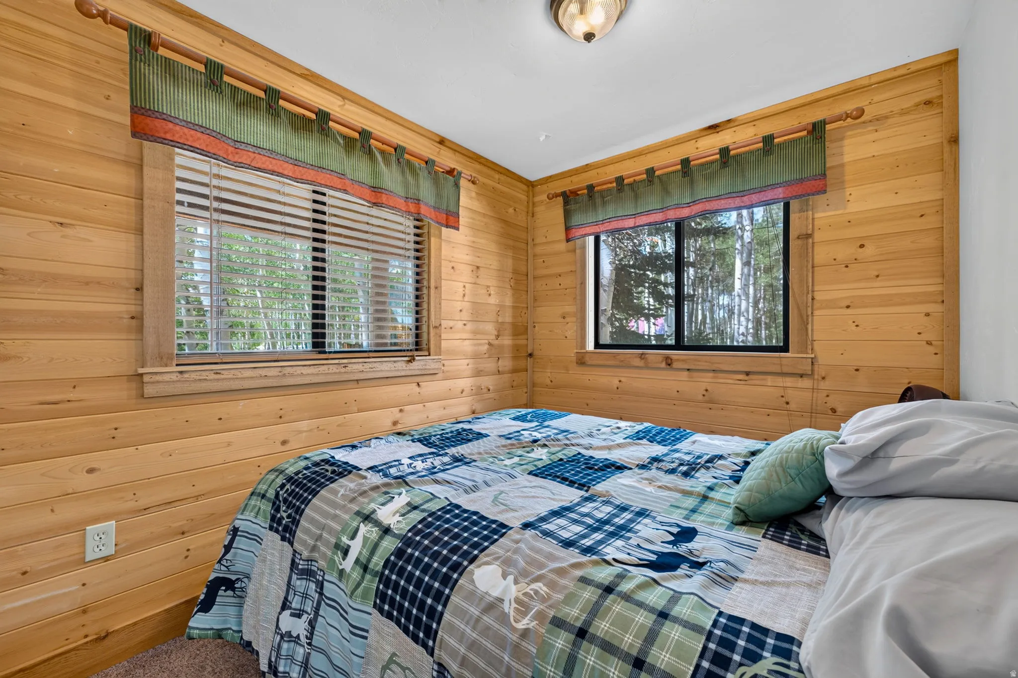 Room featuring horizontal wood paneling and two windows
