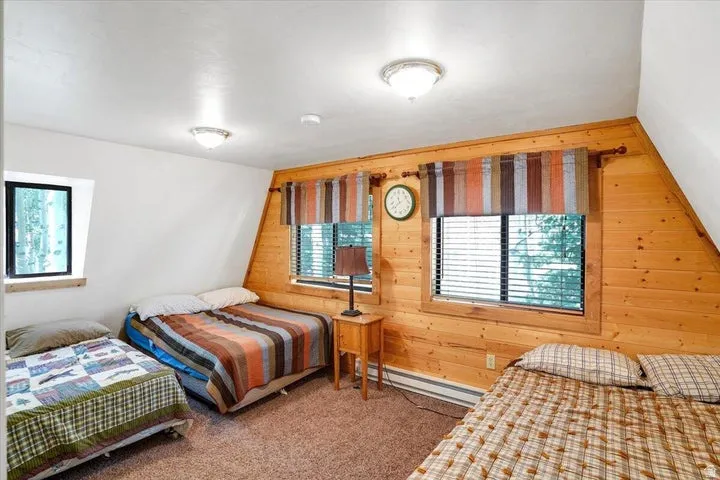 Interior room featuring wood-paneled walls and a white sloped ceiling