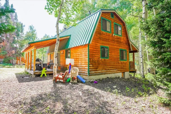 Log-style exterior with green trim and a coordinating green metal roof