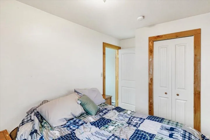 White walls with natural wood trim framing the closet and doorway