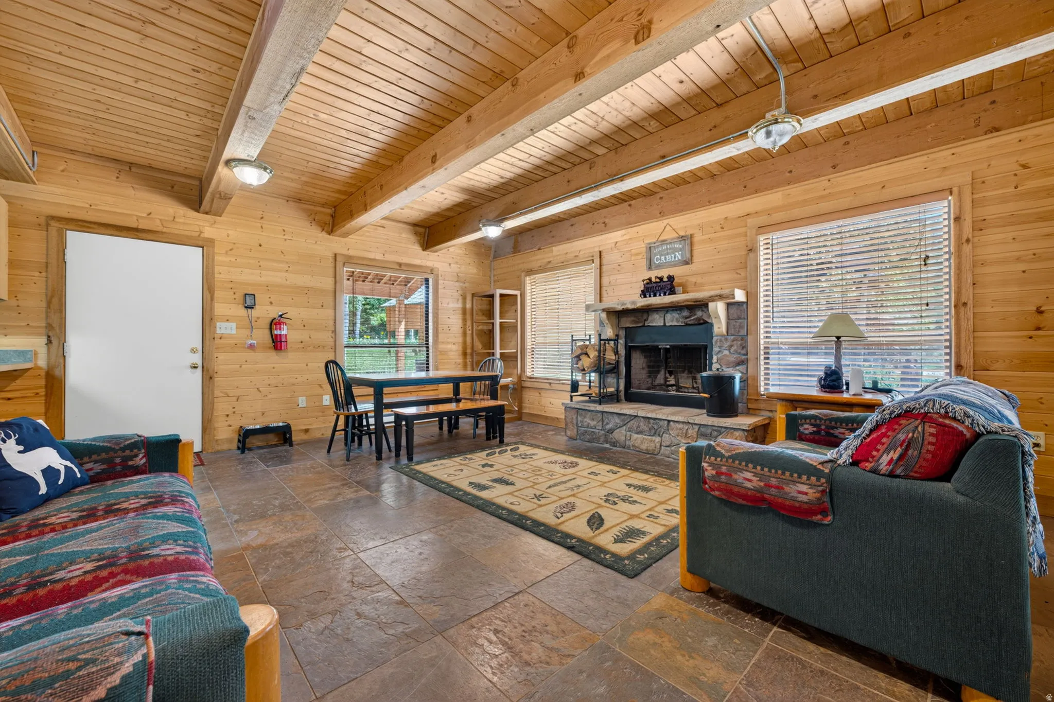 Spacious living area featuring stone-look tile flooring and extensive wood paneling throughout