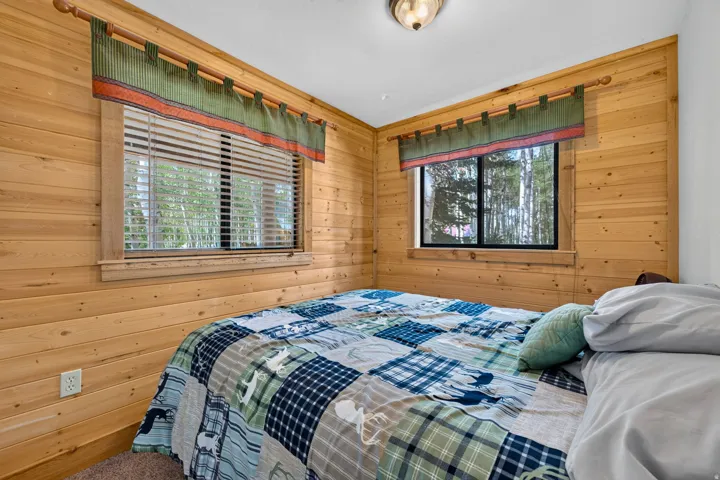Room featuring horizontal wood paneling and two windows