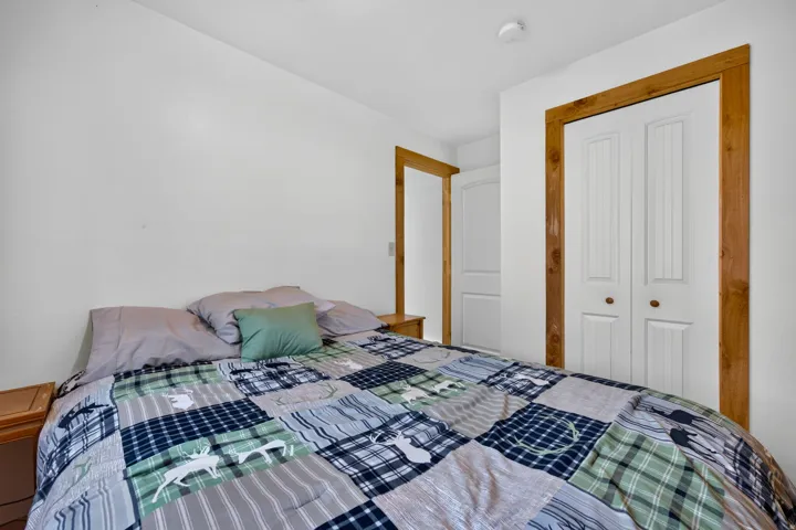 White walls with natural wood trim framing a bi-fold closet door and an additional door