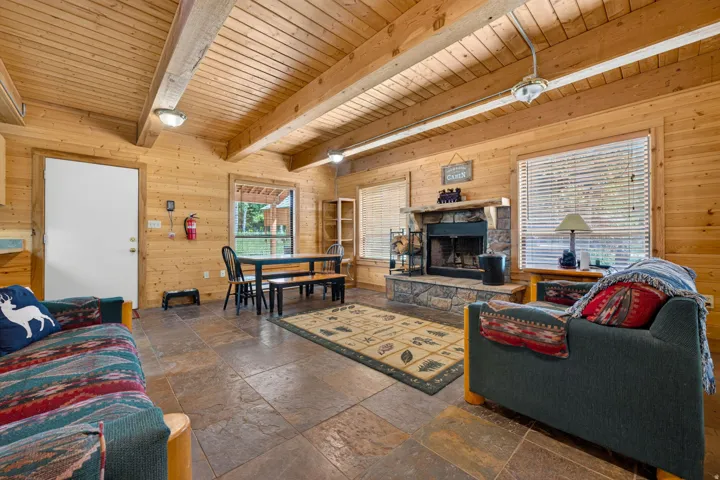 Spacious living area featuring stone-look tile flooring and extensive wood paneling throughout
