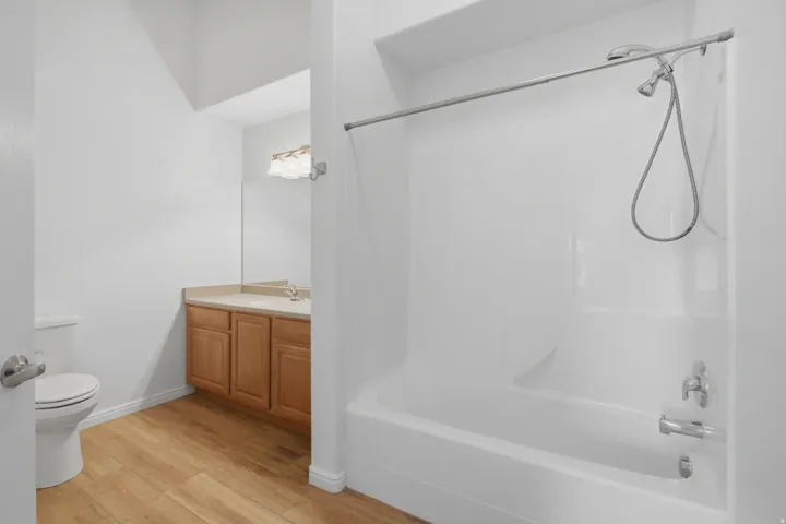 Bathroom featuring a combination bathtub and shower with a silver-finish shower head and a curved shower rod