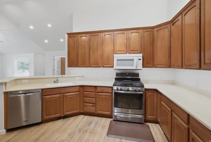 Kitchen featuring wood-finish flooring, light-toned countertops, and wood cabinetry