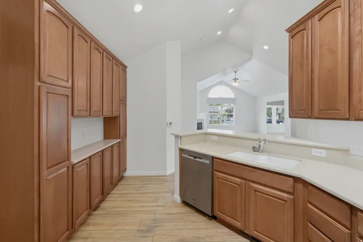 Kitchen featuring wood-finish cabinetry, light-toned countertops, and wood-finish flooring