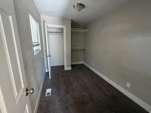 Carpeted room with a ceiling-mounted light fixture