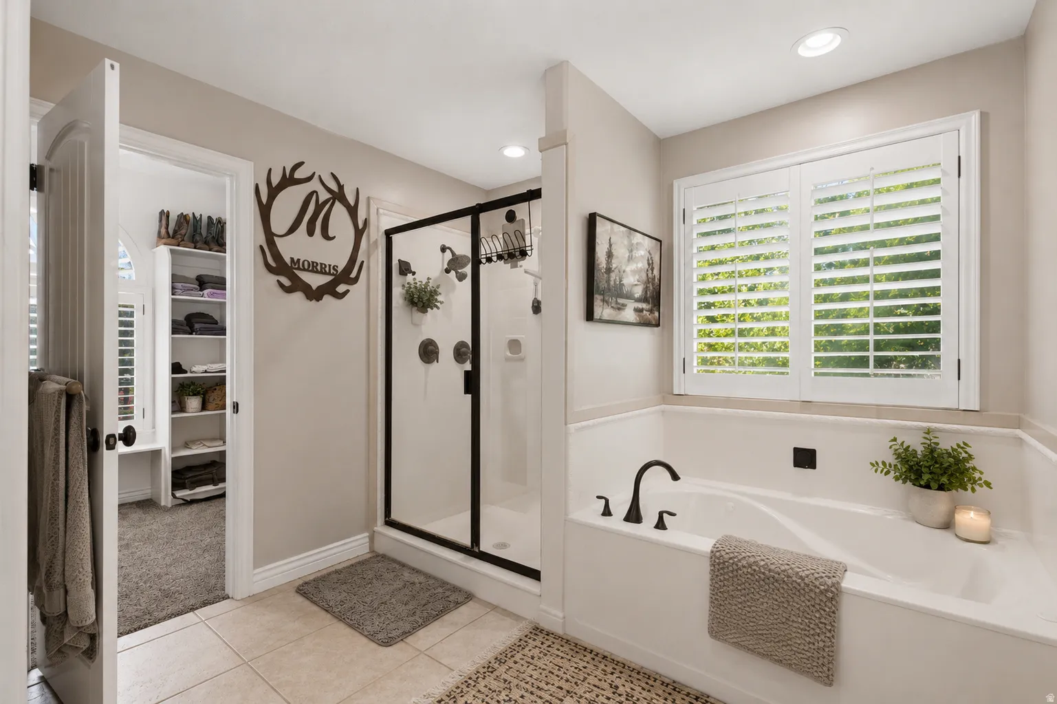 Bathroom featuring a built-in soaking tub with matte black fixtures, a glass-enclosed shower with matte black framing, and plantation shutters