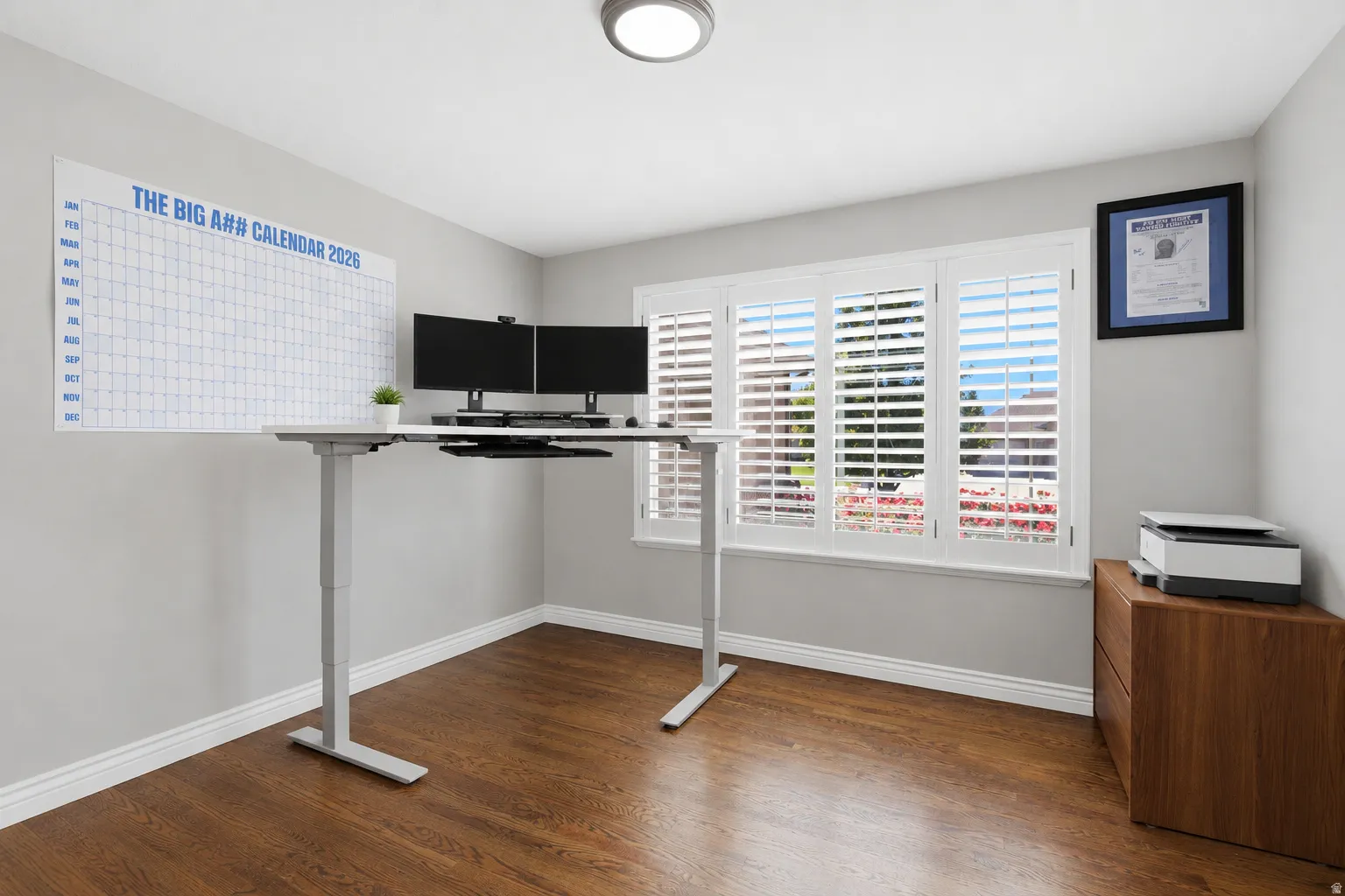 Room featuring wood-finish flooring, light gray walls, and white baseboards