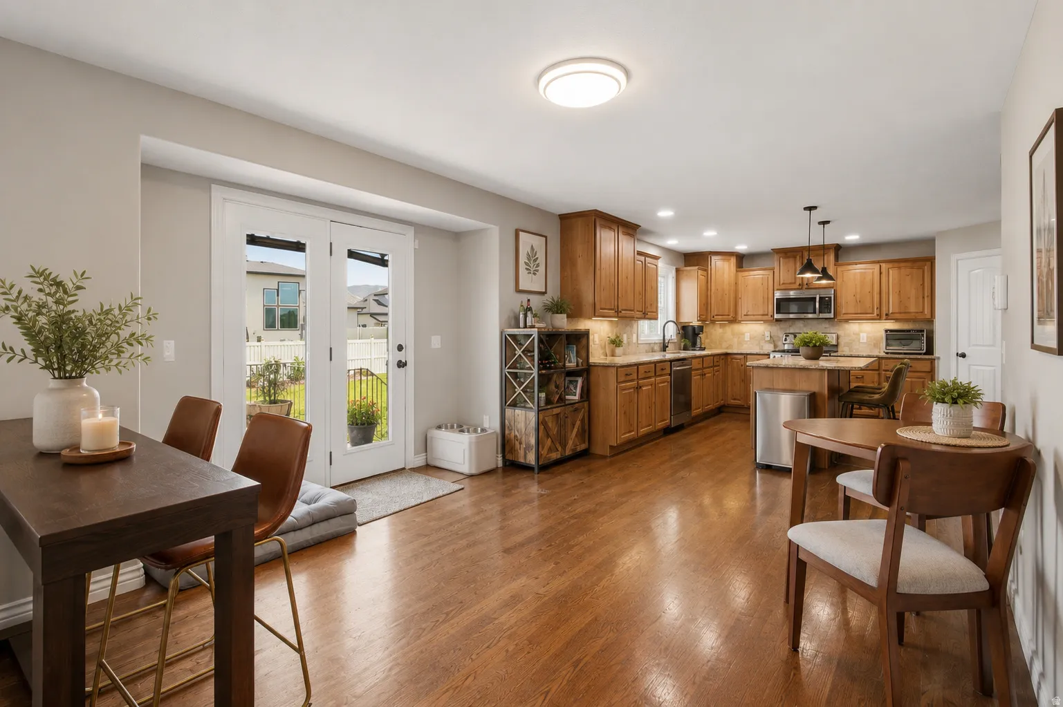 Open-concept kitchen and dining area featuring warm wood-finish flooring