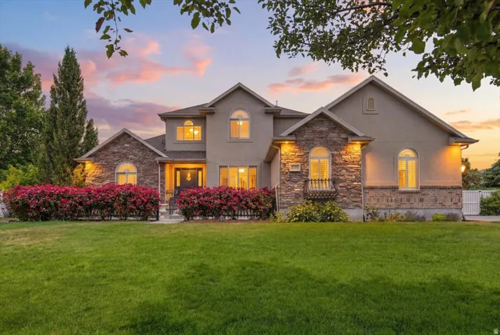Stately residence featuring a stucco and stone facade, arched windows, and a prominent front entrance