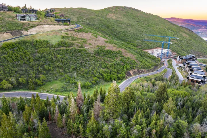 Mountainous terrain featuring winding roadways and lush green vegetation