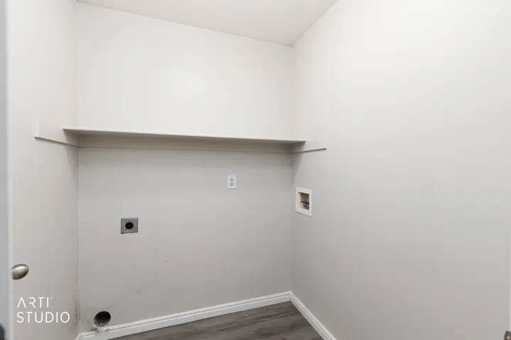 Laundry area featuring a built-in shelf, plumbing hookups, and wood-finish flooring