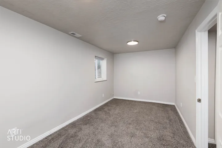 Carpeted flooring, recessed lighting, neutral wall paint, white trim, and a single window