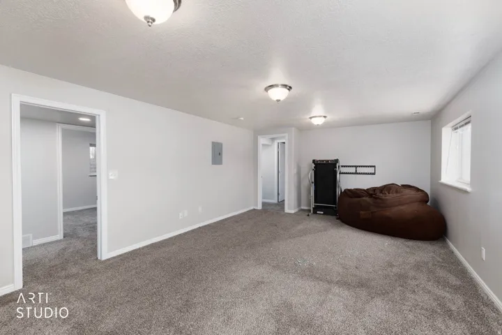 Recessed lighting, neutral wall paint, and gray carpet