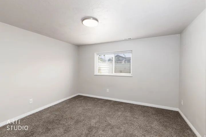 Neutral wall paint, brown carpeting, recessed window, flush-mount ceiling light fixture, and white trim