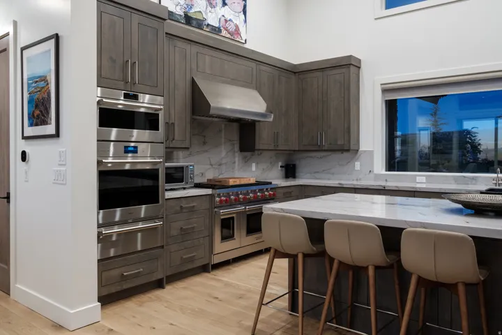 Gourmet kitchen featuring wood-finish cabinetry, stainless steel appliances, and a generously sized island with a stone countertop