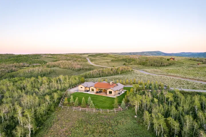 Expansive property featuring a stone and stucco residence with a prominent chimney