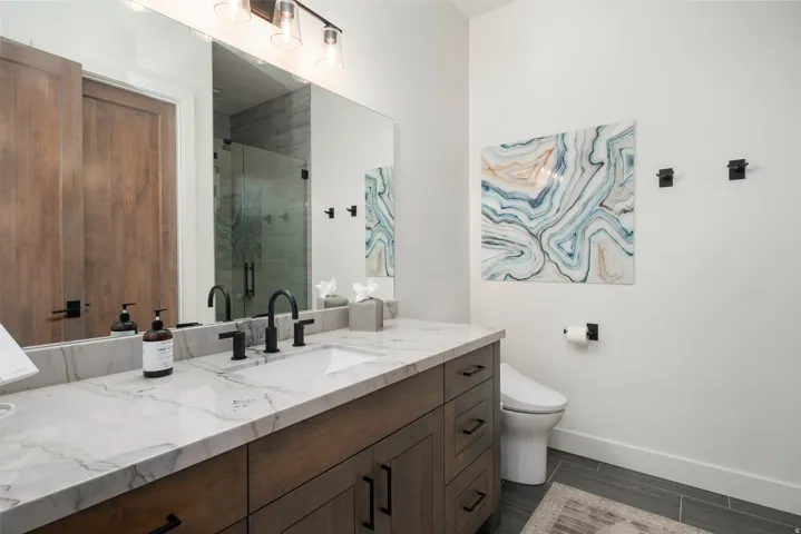 Modern bathroom featuring a wood-finish vanity with a single undermount sink