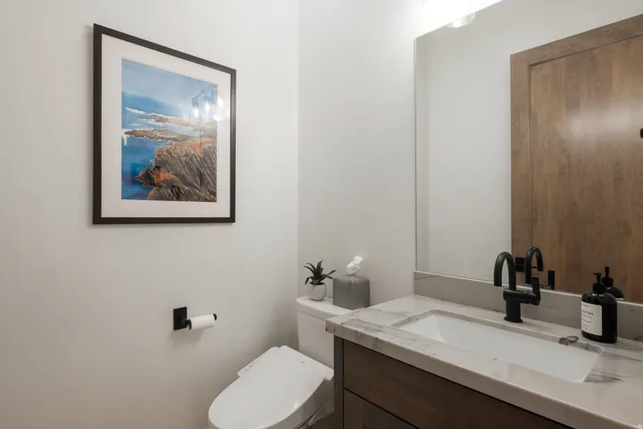 Modern vanity with a rectangular undermount sink, stone countertop, and matte black faucet