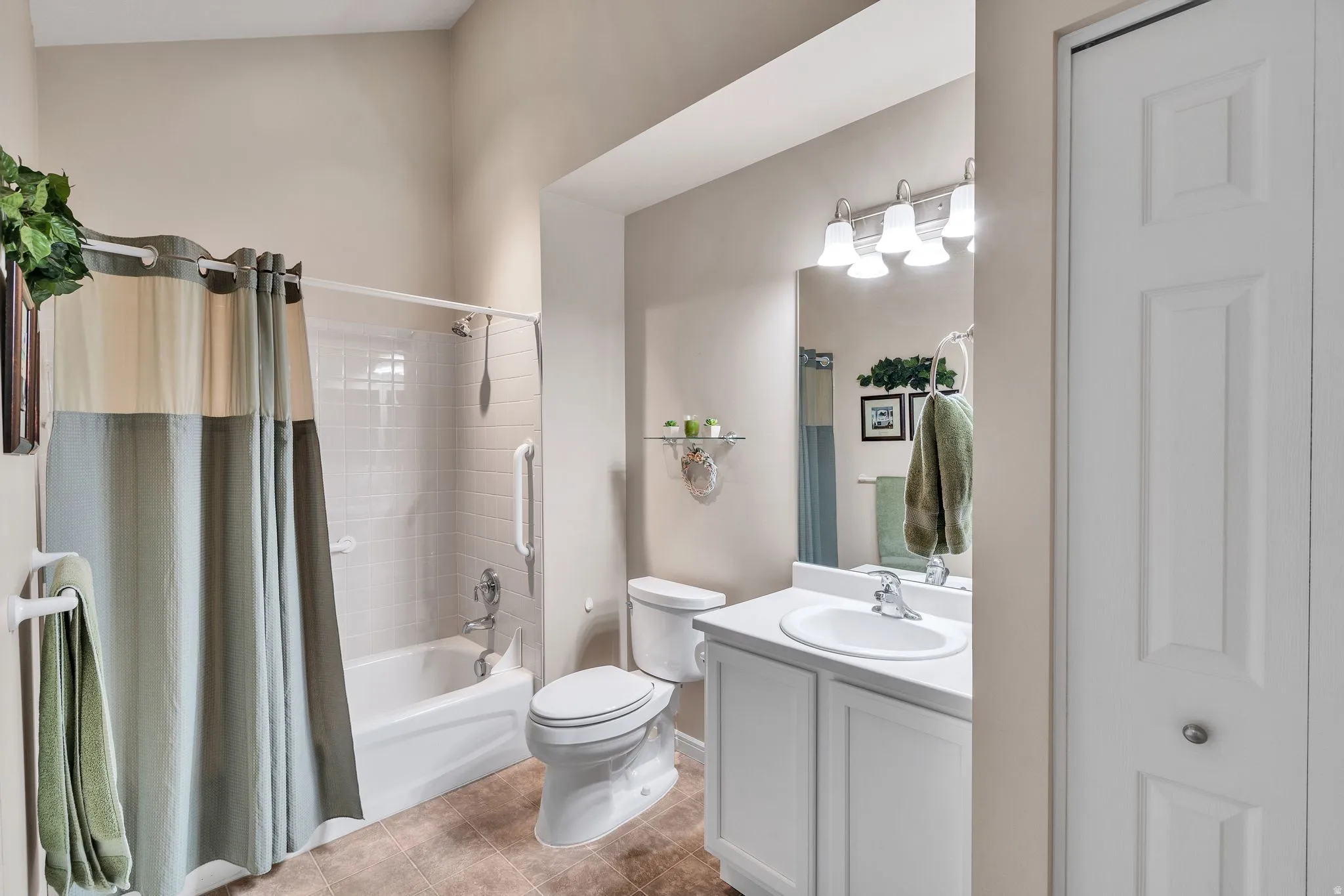 Second Bathroom featuring a white vanity with integrated sink, a large wall-mounted mirror, and a three-light fixture